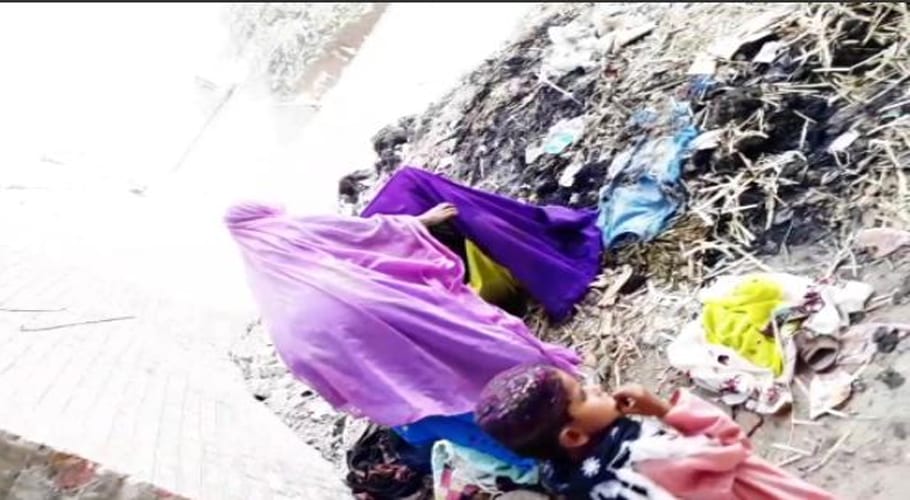 a woman gives birth to a baby on a pile of rubbish