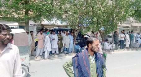Crowds gather outside DC Korangi’s office to receive rations