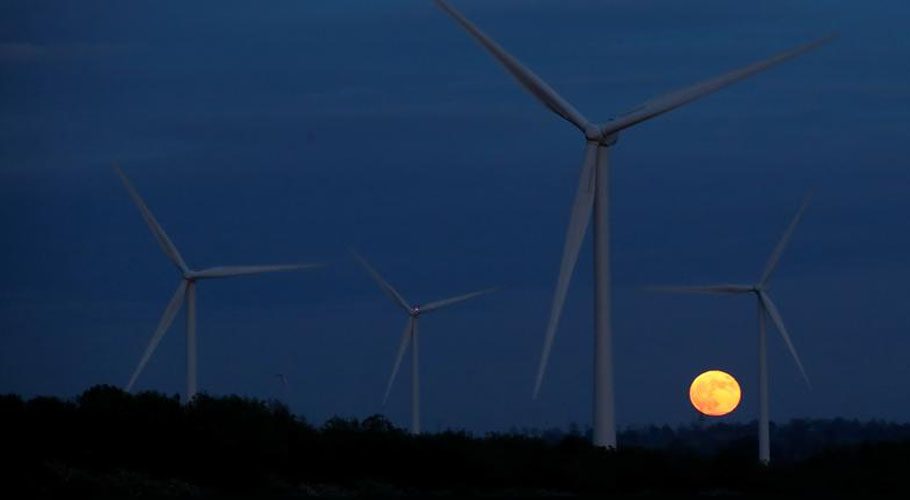 The full moon, known as the "Super Flower Moon", rises in the sky as wind turbines are seen in the foreground, in Lilbourne, Britain. Source: Reuters 