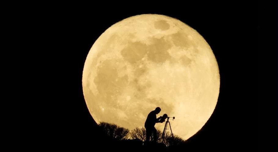  A man uses a telescope to observe the full moon, known as the "Super Flower Moon" as it rises over Arguineguin, in the south of Gran Canaria, Spain. Source: Reuters 