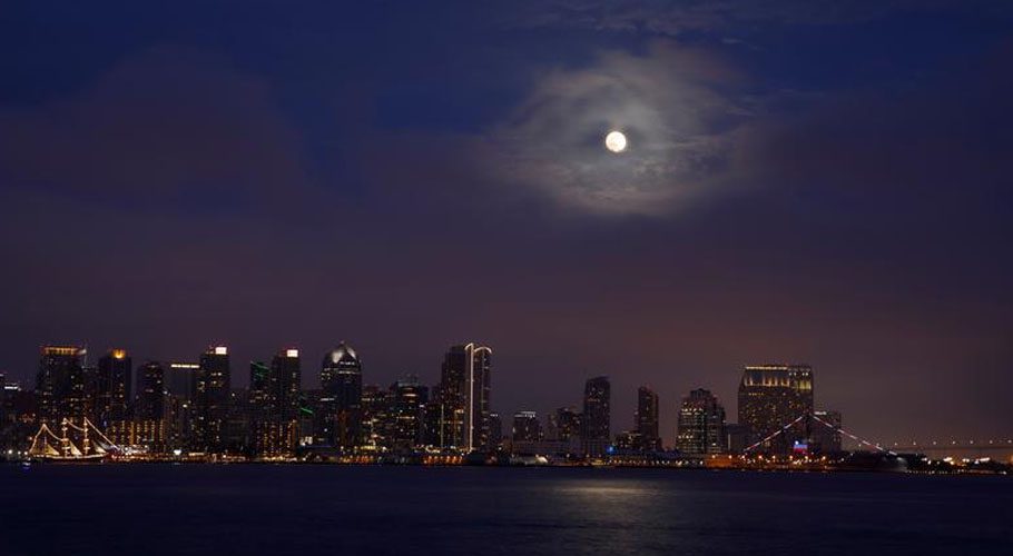 A Super Flower Moon rises through low clouds above the city of San Diego, California. Source: Reuters 
