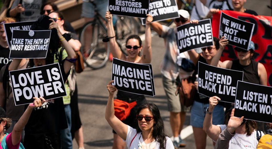People hold signs on the Brooklyn Bridge on Juneteenth, which commemorates the end of slavery in Texas. Source: Reuters
