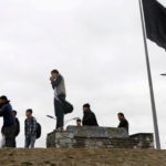 Youths take pictures next to an Afghan flag on a hilltop overlooking Kabul, Source: Reuters.