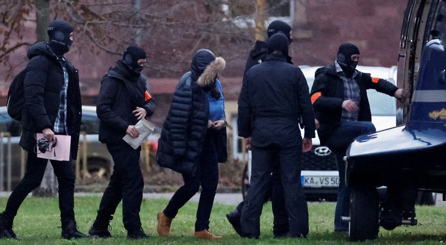 Police escorts a person after 25 suspected members and supporters of a far-right group were detained during raids across Germany, in Karlsruhe, Germany December 7, 2022. REUTERS/Heiko Becker