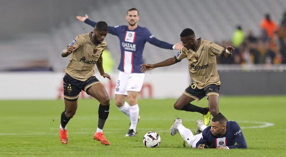 Ligue 1 - RC Lens v Paris St Germain - Stade Bollaert-Delelis, Lens, France - January 1, 2023 Paris St Germain's Kylian Mbappe in action with RC Lens' Kevin Danso and Salis Abdul Samed REUTERS/Pascal Rossignol