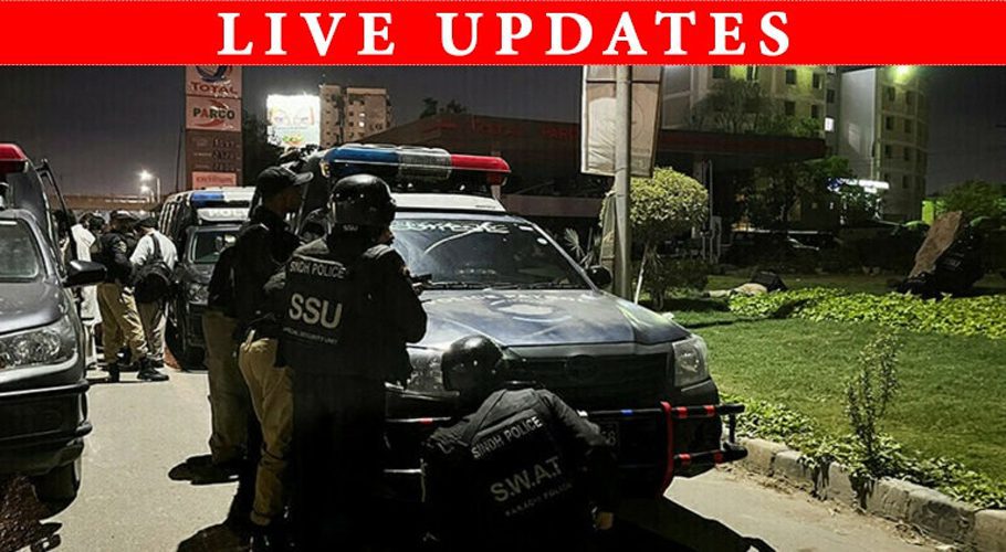 Police officers take position after a police office building was attacked by gunmen in Karachi, on Friday. — Reuters
