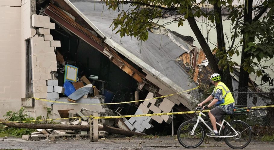 A man views damage to a building caused by recent flooding, Wednesday, Sept. 13, 2023, at the Hilton & Cook Marketplace in Leominster, Mass. (AP Photo/Robert F. Bukaty)