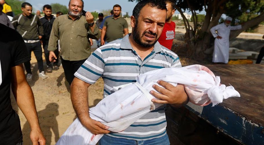 FILE A mourner carries the body of a child, during the funeral of Palestinians from al-Astal family, who were killed in Israeli strikes, in Khan Younis in the southern Gaza Strip October 22, 2023. REUTERS/Ibraheem Abu Mustafa Acquire Licensing Rights