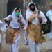 Students wearing facemasks walk through a street to their school in Peshawar. (File/AFP)