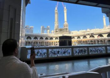 A Muslim man uses a mobile phone during Umrah, at the Grand Mosque, while construction cranes are seen in the background, in the holy city of Mecca, Saudi Arabia, December 18, 2023. (Reuters)