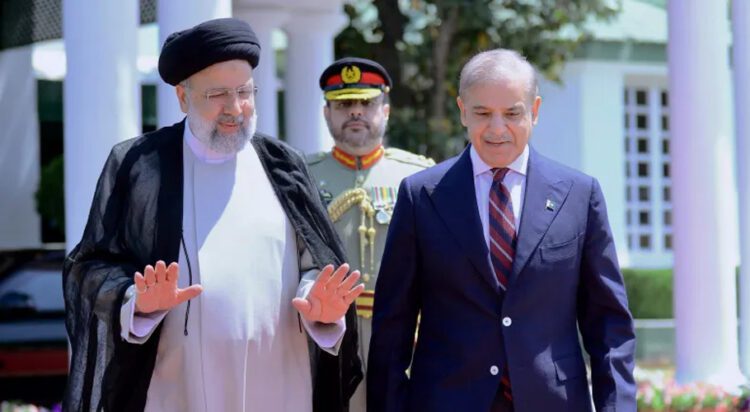 Iranian President Ebrahim Raisi, left, walks with Pakistan's Prime Minister Shehbaz Sharif during a welcome ceremony in the prime minister house in Islamabad on April 22. [Prime Minister Office via AP]