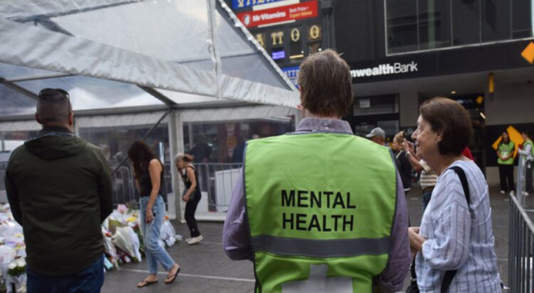A mental health professional offers support to people offering tributes at the memorial for the victims of the Bondi Junction Westfield Massacre in Sydney on April 18, 2024. (AFP)