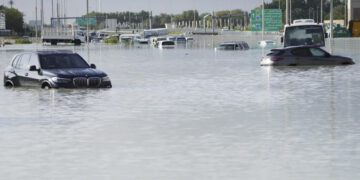 Vehicles sit abandoned in floodwater covering a major road in Dubai, United Arab Emirates, April 17, 2024. (AP Photo/Jon Gambrell)