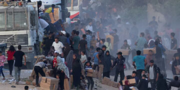 Palestinians climb onto trucks to grab aid that was delivered into Gaza through a U.S.-built pier, amid the ongoing conflict between Israel and the Palestinian Islamist group Hamas, as seen from central Gaza Strip, May 18, 2024. REUTERS/Ramadan Abed/File Photo