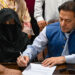 Pakistan's former Prime Minister, Imran Khan (R) along with his wife Bushra Bibi (L) looks on as he signs surety bonds for bail in various cases, at a registrar office in the High court, in Lahore on July 17, 2023. (AFP/File)