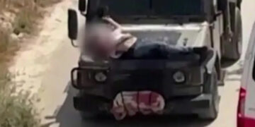 Israeli army straps Palestinian on military jeep during raid in Jenin, in this screengrab from a video, in the Israeli-occupied West Bank, June 22, 2024. (Reuters)