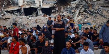 Palestinians hold Eid al-Adha prayers by the ruins of ar-Rahma Mosque destroyed by Israeli air strikes, in Khan Younis, in the southern Gaza Strip. [Mohammed Salem/Reuters]