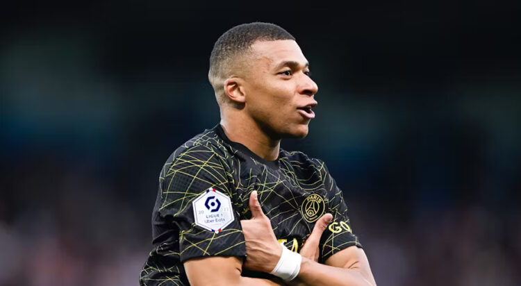Kylian Mbappé celebrating a goal with his trademark celebration. Victor Velter/Shutterstock