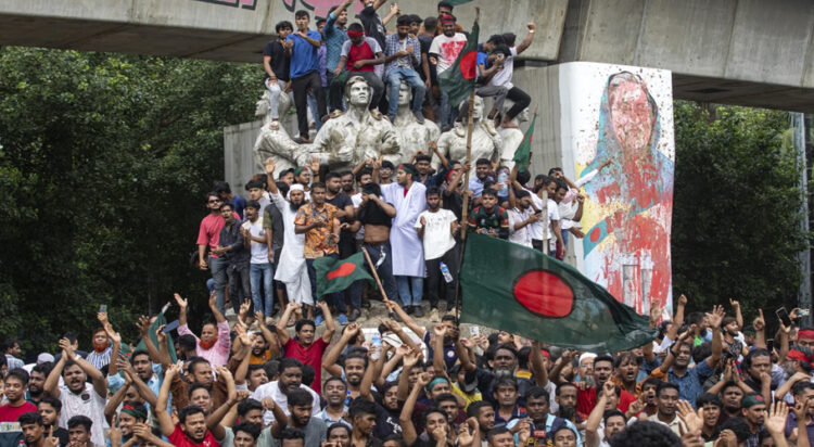 Protesters climb a public monument as they celebrate the news of Prime Minister Sheikh Hasina’s resignation, in Dhaka, Bangladesh, Monday, Aug. 5, 2024. (AP Photo/Rajib Dhar)