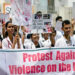 Doctors hold posters to protest the rape and murder of a young medic from Kolkata, at the Government General Hospital in Vijayawada on August 14 [Idrees Mohammed/AFP]