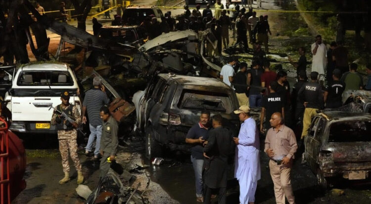 Security officials on Monday examine the site of a suicide attack that killed two Chinese nationals outside the international airport in Karachi, Pakistan. Photo: AP