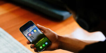 A high school student poses with his mobile phone showing his social media applications in Melbourne, Australia, November 28, 2024. REUTERS/Asanka Brendon Ratnayake