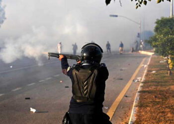 A policeman fires rubber bullets to disperse PTI supporters in Islamabad on November 26, 2024. — AFP