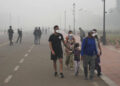 A foreign tourist family walks wearing face mask amidst a thick layer of smog as air pollution shoots up in New Delhi, India, Monday, Nov. 18, 2024. (AP Photo/Manish Swarup)