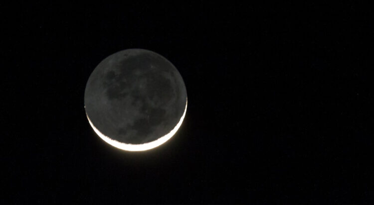 FILE/ A new moon with a slim, illuminated crescent rises in a black sky (Image credit: Getty)