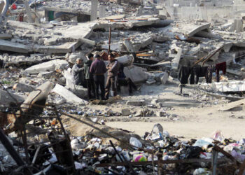 Palestinians stand among the rubble of houses destroyed in previous Israeli strikes, amid ceasefire negotiations with Israel, in Gaza City, January 15, 2025. REUTERS/Mahmoud Issa