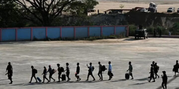 Alleged victims of scam centres in Kyaukhat town in Myanmar’s Kayin State walk in line as they are met by the Thai Army after crossing the Thai-Myanmar border. AFP