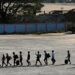 Alleged victims of scam centres in Kyaukhat town in Myanmar’s Kayin State walk in line as they are met by the Thai Army after crossing the Thai-Myanmar border. AFP