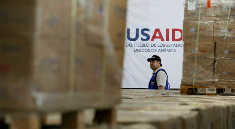 A man walks past boxes of USAID humanitarian aid at a warehouse in Colombia in 2019.Fernando Vergara / AP file