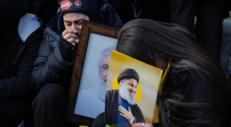 Mourners hold pictures of Nasrallah, right, and Safieddine at the funeral procession [Bilal Hussein/AP]