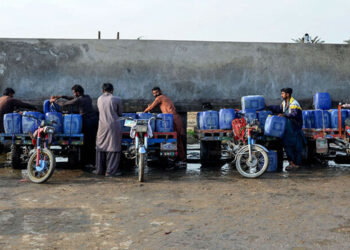 Vendors load cans of drinking water for sale on their motorcycle carts, as they fill them from a private water supply plant in Jacobabad in southern Sindh province on February 18. — AFP