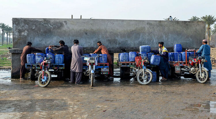 Vendors load cans of drinking water for sale on their motorcycle carts, as they fill them from a private water supply plant in Jacobabad in southern Sindh province on February 18. — AFP