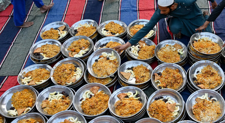 Volunteers arrange plates of iftar meals prepared for Muslims waiting to break their fast on the first day of the Islamic holy fasting month of Ramadan at Memon mosque in Karachi on March 2, 2025. (AFP)
