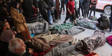 Relatives stay around the bodies of victims killed in an Israeli strike at Al-Mamdani Hospital in Gaza City on March 18, 2025. © Omar Al-Qatta, AFP