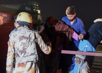 A soldier (L) works to evacuate freed train passengers at the Mach railway station, which has been turned into a makeshift hospital, after Pakistani security forces freed nearly 80 passengers following a security operation against armed militants who ambushed the train in the remote mountainous area, in Mach on March 11, 2025. — AFP