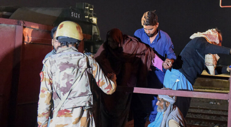 A soldier (L) works to evacuate freed train passengers at the Mach railway station, which has been turned into a makeshift hospital, after Pakistani security forces freed nearly 80 passengers following a security operation against armed militants who ambushed the train in the remote mountainous area, in Mach on March 11, 2025. — AFP