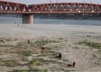 People walk on the dry riverbed of the Indus River in Hyderabad, Pakistan April 24, 2025. REUTERS/Yasir Rajput/File Photo
