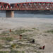 People walk on the dry riverbed of the Indus River in Hyderabad, Pakistan April 24, 2025. REUTERS/Yasir Rajput/File Photo