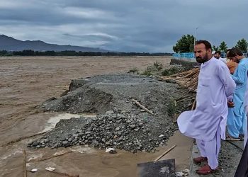 Local residents at the Swat River, which is overflowing due to pre-monsoon heavy rains in the area on the outskirts of Mingora, the main town of Pakistan's Swat Valley [Sherin Zada/AP]