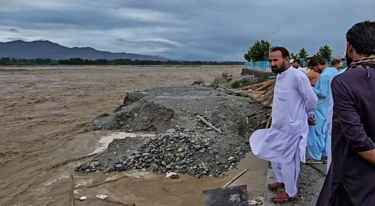 Local residents at the Swat River, which is overflowing due to pre-monsoon heavy rains in the area on the outskirts of Mingora, the main town of Pakistan's Swat Valley [Sherin Zada/AP]