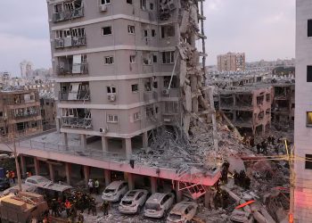 People stand near a residential building that was hit following missile attack from Iran on Israel, at central Israel June 15, 2025. REUTERS/Tomer Appelbaum