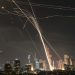 A projectile hit buildings in Tel Aviv as Israel’s Iron Dome air-defense system fired to intercept missiles on Friday. Photo: Leo Correa/Associated Press