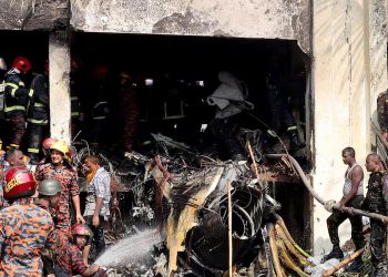 Firefighters and army members work next to the wreckage of an air force training aircraft after it crashed into Milestone College campus, in Dhaka, Bangladesh, July 21, 2025. REUTERS/Stringer