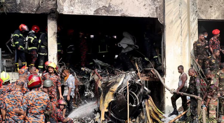 Firefighters and army members work next to the wreckage of an air force training aircraft after it crashed into Milestone College campus, in Dhaka, Bangladesh, July 21, 2025. REUTERS/Stringer