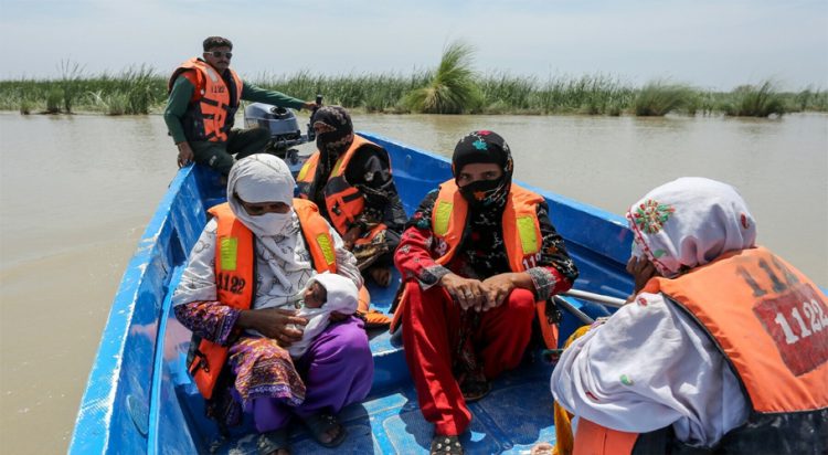 Rescue personnel evacuate villagers by boat from a flooded village following heavy rains in the Taunsa district of Punjab on July 16, 2025. — AFP