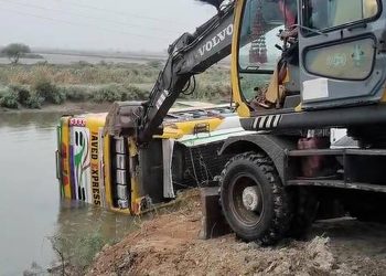 A crane operator attempts to recover an overturned bus from a water canal in Pakistan's southern district of Thatta on July 20, 2025. (Rescue Service Thatta)